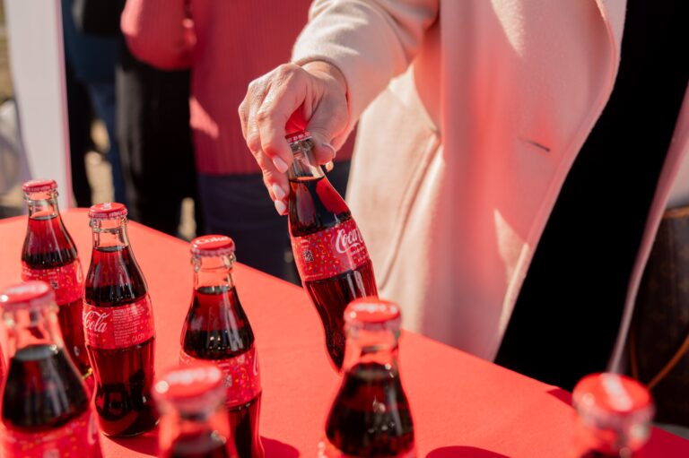 Guest picking up a Coca-Cola bottle at a groundbreaking