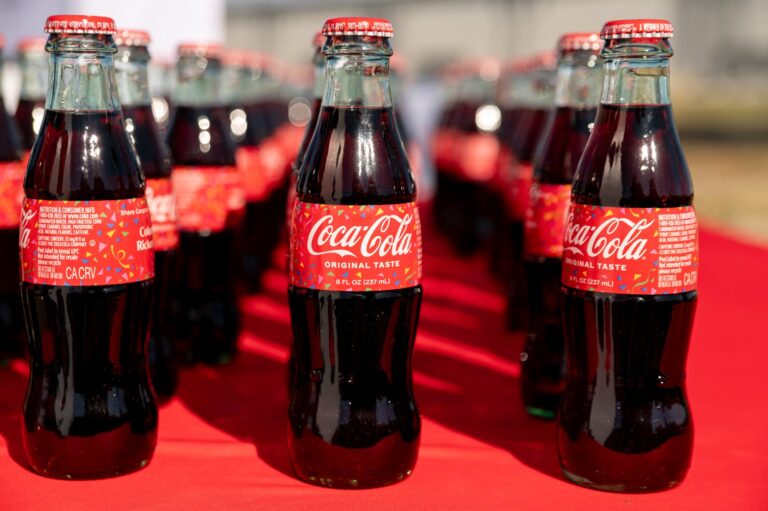 Coca-Cola bottles on a red table at a groundbreaking