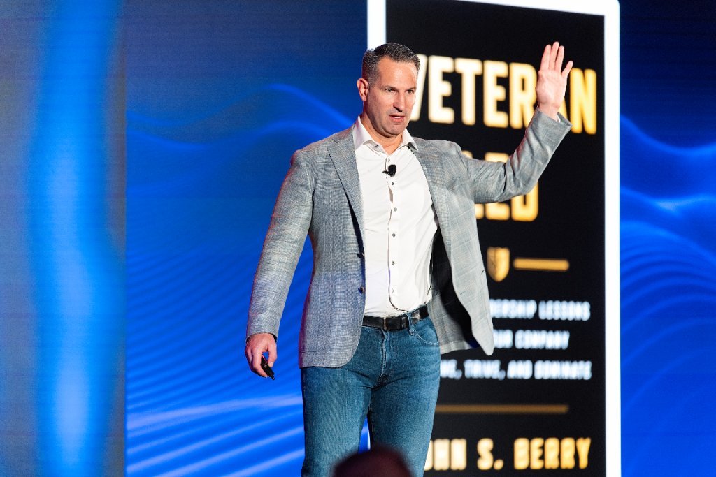 Keynote speaker waving on stage at the NeoStella conference