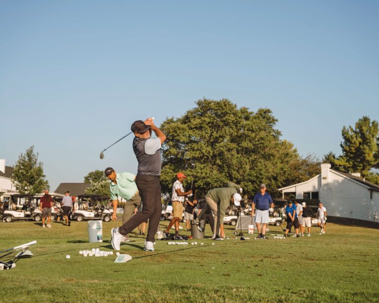 Golfer swinging on the driving range at the ATSG Charity Golf Classic 2025