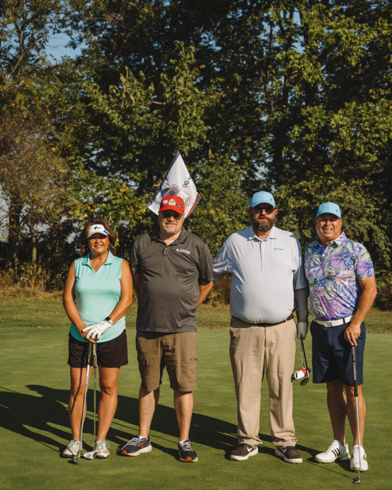 Foursome team photo by the flag at the ATSG Charity Golf Classic 2025
