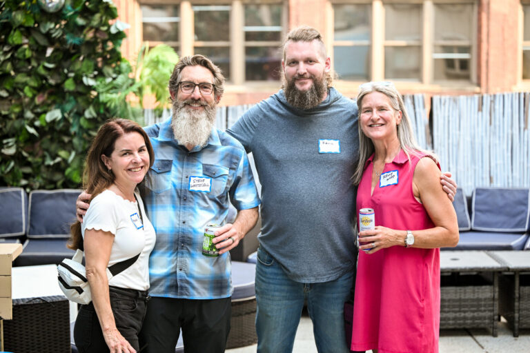 Colleagues posing together on the rooftop at the AWE Symposium reception at Joy District, Chicago