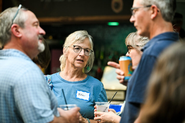 Attendees sharing a laugh over drinks at the AWE Symposium reception at Joy District, Chicago