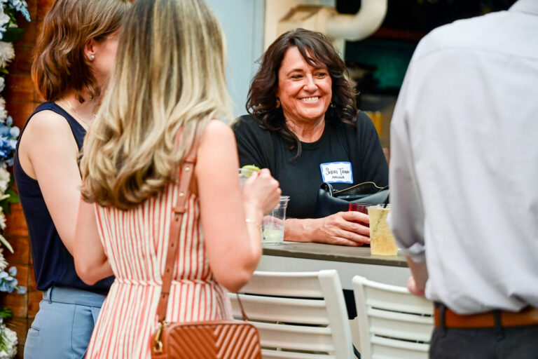 Guests chatting by the rooftop bar at the AWE Symposium reception at Joy District, Chicago