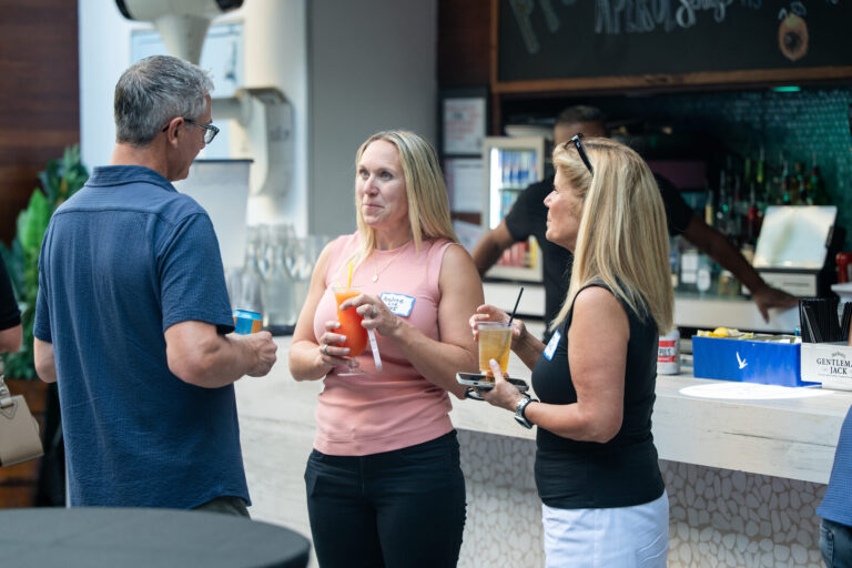 Guests talking by the bar at the AWE Symposium reception at Joy District, Chicago