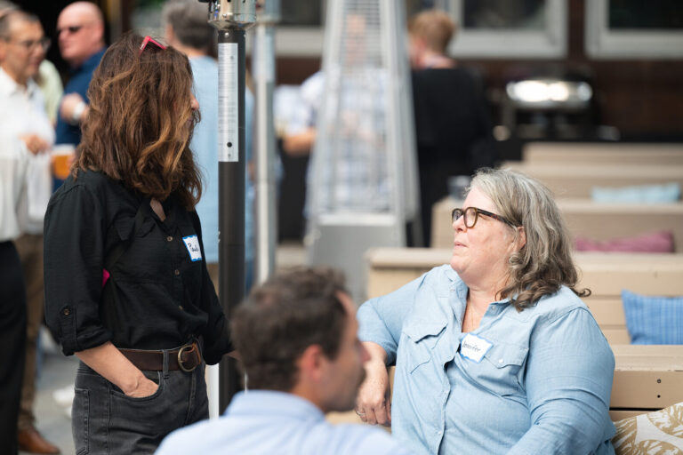 Attendees in conversation on the patio at the AWE Symposium reception at Joy District, Chicago