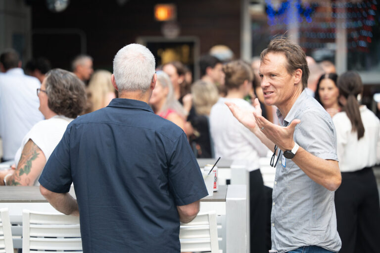 Guests networking across the rooftop at the AWE Symposium reception at Joy District, Chicago