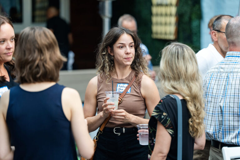 Guests chatting with drinks at the AWE Symposium reception at Joy District, Chicago