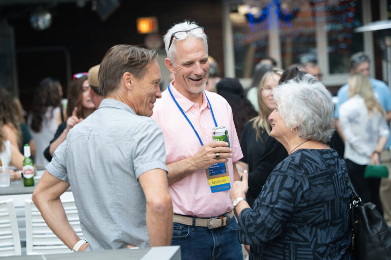 Attendees laughing together at the AWE Symposium reception at Joy District, Chicago