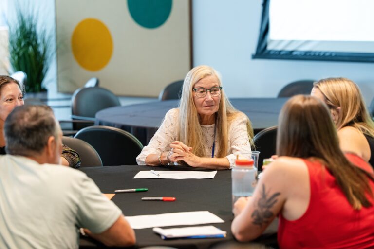 Attendee listening during a table discussion at the AWE symposium