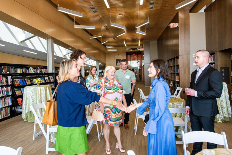 Guests greeting each other at the berkleyOne reception in the museum library