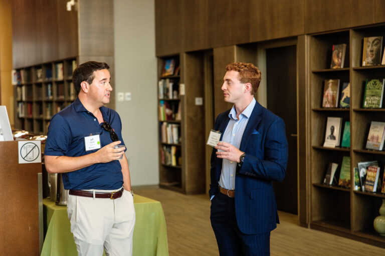 Guests talking among the bookshelves of the Cincinnati Art Museum library