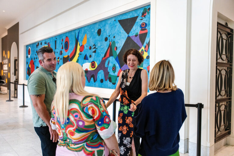 Guests in front of a large mural during the museum tour