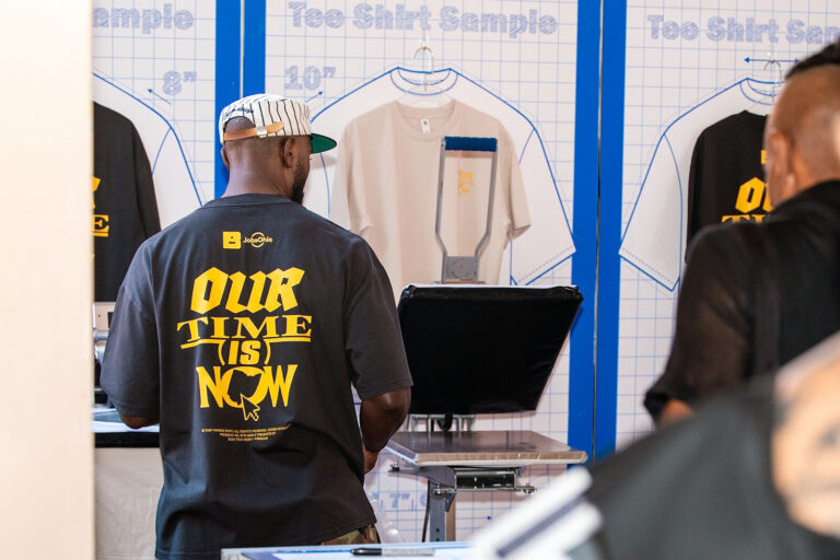 Attendee getting a custom "Our Time Is Now" T-shirt printed at Black Tech Week 2026