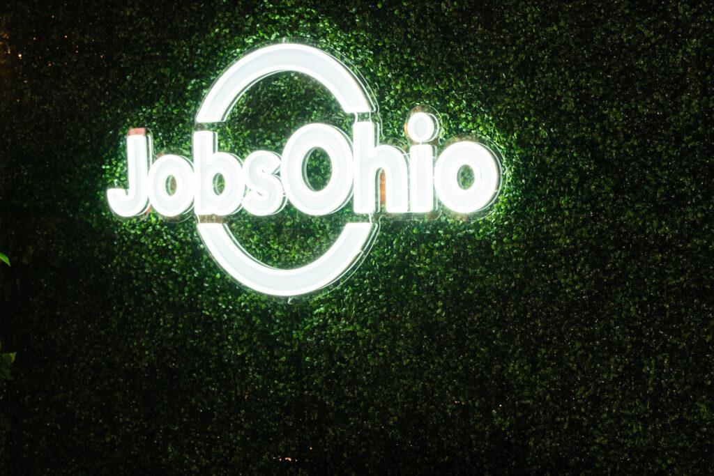 JobsOhio neon sign on a greenery wall at The Backstage Event Center
