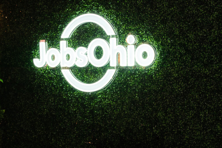 JobsOhio neon sign on a greenery wall at The Backstage Event Center
