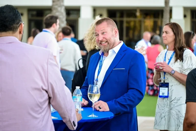 Attendee holding a glass of wine at a networking reception – Creative Soul Studios