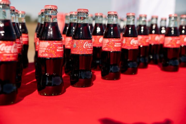 Rows of branded glass beverage bottles at a corporate event – Creative Soul Studios