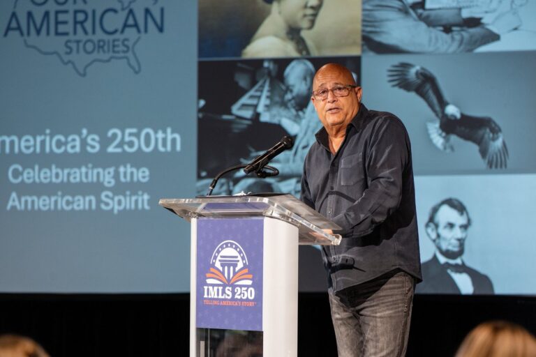 Speaker delivering remarks from a branded podium – Creative Soul Studios