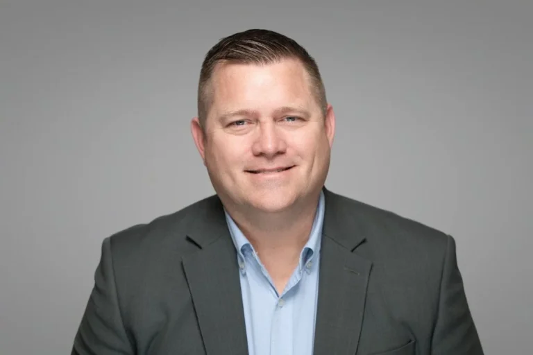 Smiling man in a gray suit, executive headshot – Creative Soul Studios