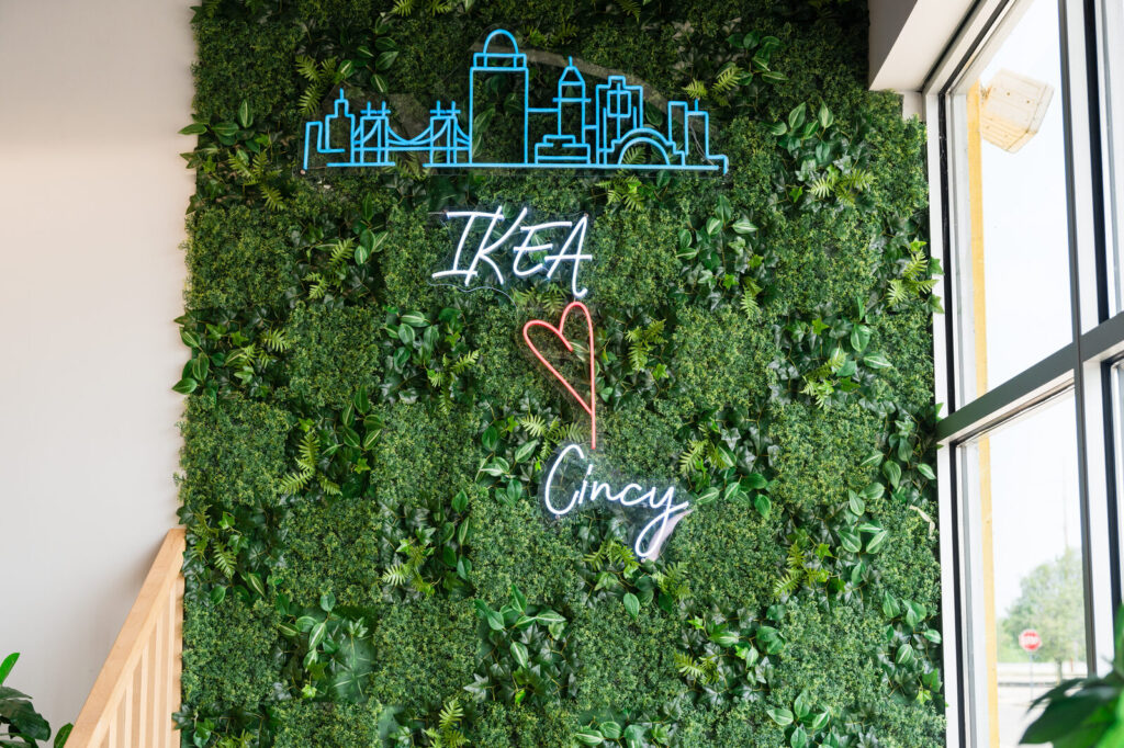IKEA ♥ Cincy neon sign on a greenery wall at the IKEA Grad Bash Cincinnati 2023