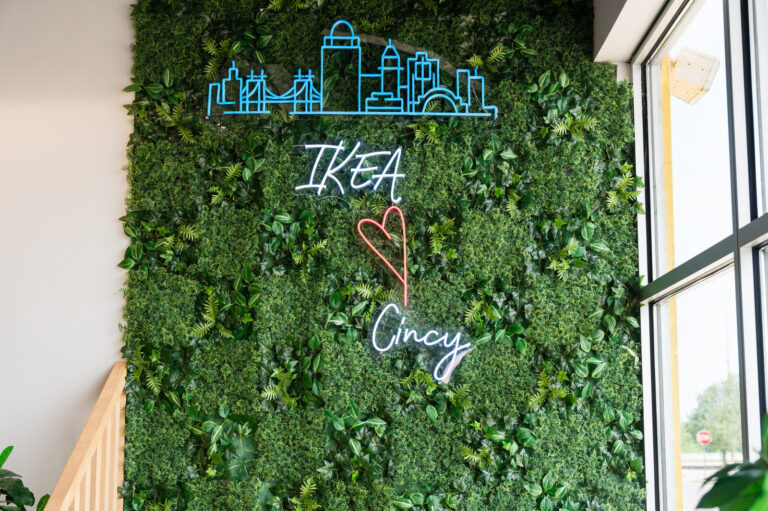 IKEA ♥ Cincy neon sign on a greenery wall at the IKEA Grad Bash Cincinnati 2023
