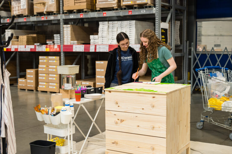 Guests painting an IKEA dresser at the IKEA Grad Bash Cincinnati 2023