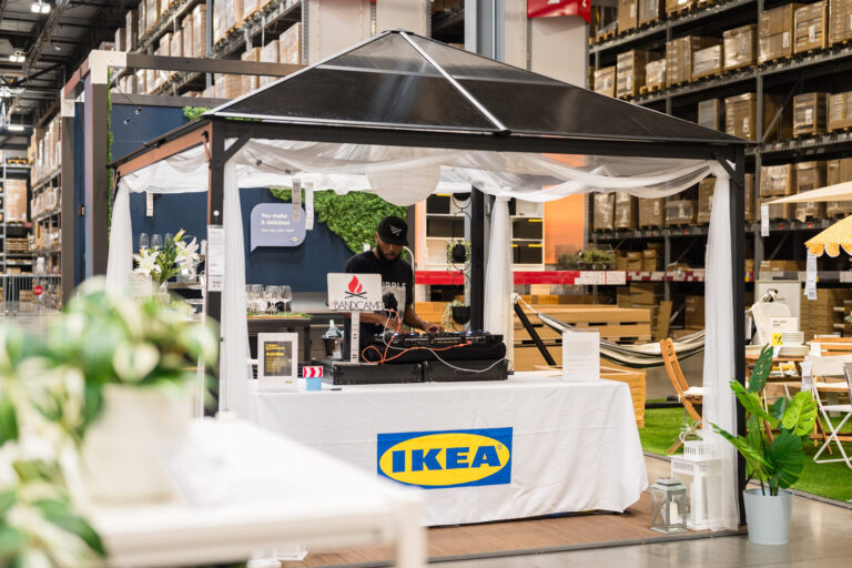 DJ booth under a canopy with IKEA branding at the IKEA Grad Bash Cincinnati 2023