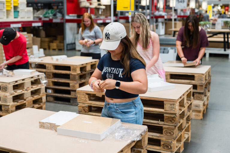 Graduates at DIY project tables on pallets at the IKEA Grad Bash Cincinnati 2023