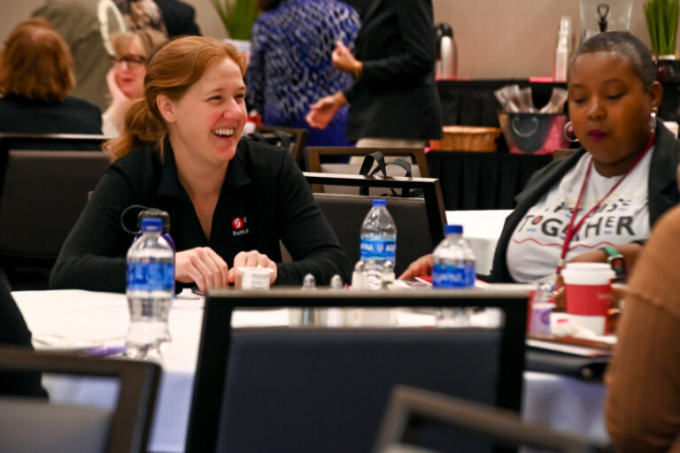Attendees laughing at a table during LeaderShift in Dayton