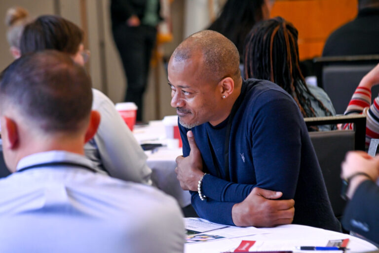 Attendees in conversation at a round table during LeaderShift