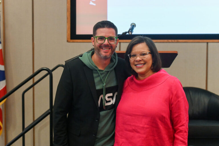 Two attendees posing near the stage at LeaderShift