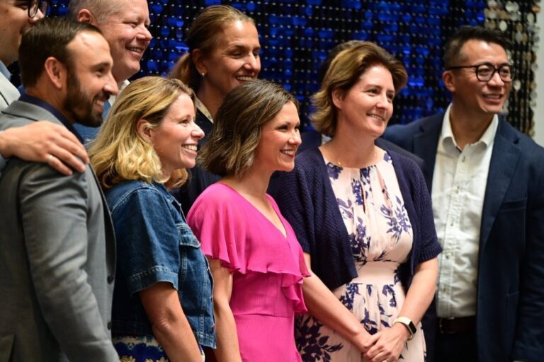 Audience members smiling during a conference session – Creative Soul Studios