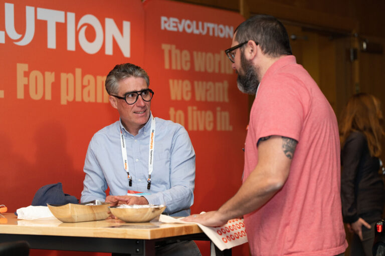 Attendees meeting at the Revolution booth at NABSA