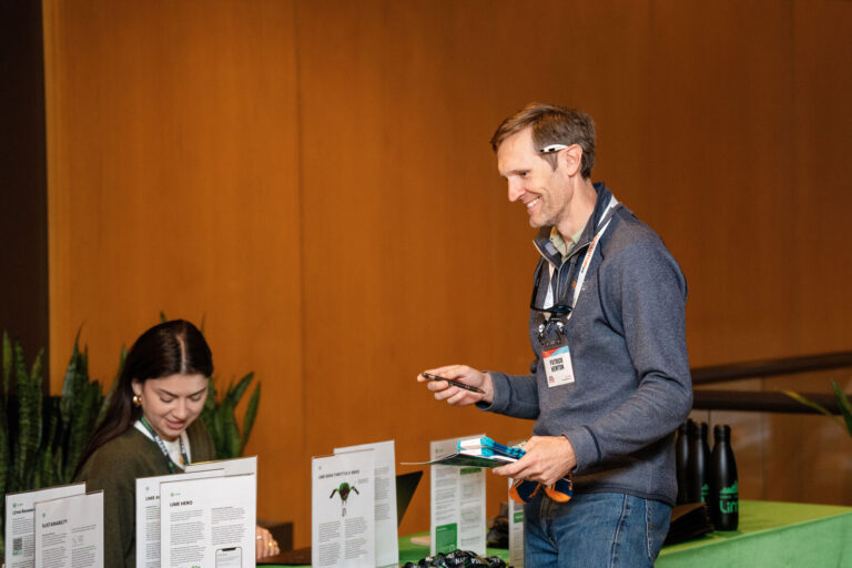 Exhibitor greeting attendees at an expo table at NABSA 2026