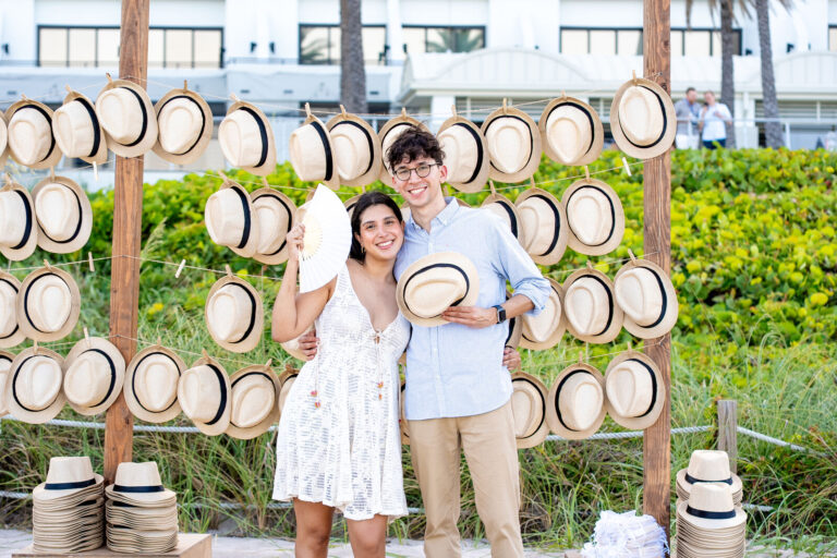 Guests at a hat wall activation on the lawn at Fort Lauderdale Marriott Harbor Beach