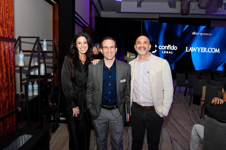 Speakers posing in front of sponsor screens at NeoSummit