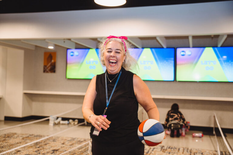 Guest holding a basketball at a P&G team event at TQL Stadium