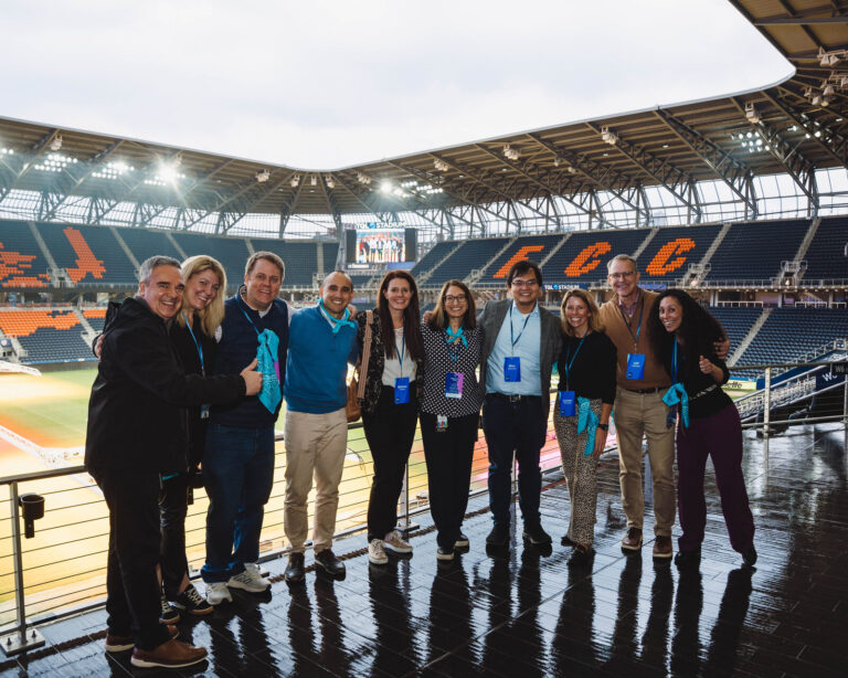 P&G team posing in front of the TQL Stadium seats