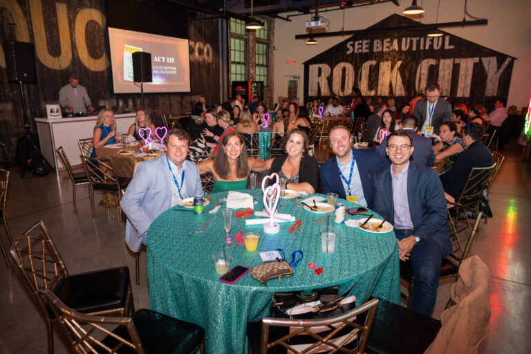 Guests at a table under the Rock City sign at the P&G Baby Care celebration, American Sign Museum Cincinnati