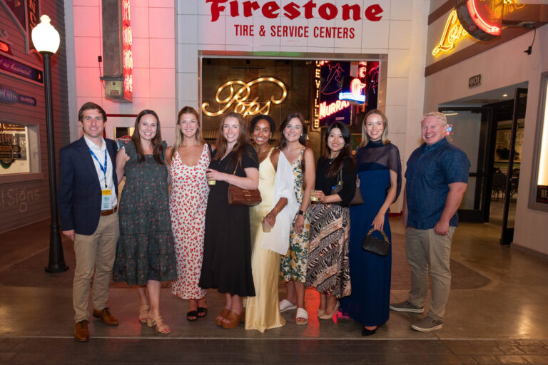Team photo under the Firestone sign at the P&G Baby Care celebration, American Sign Museum Cincinnati