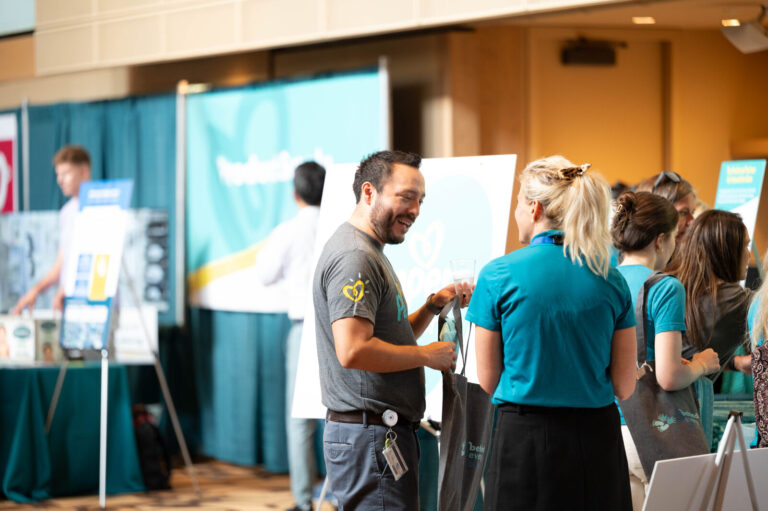 Attendees at a sponsor booth at the P&G Baby Care event, Music Hall Cincinnati