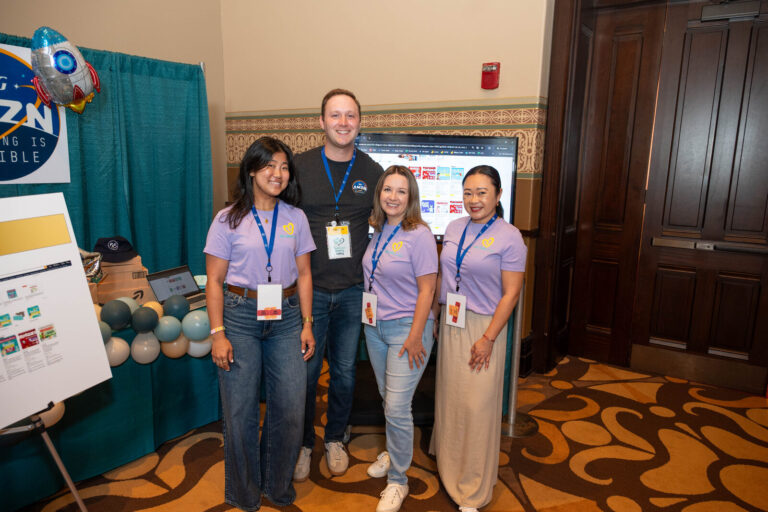 Team posing at a booth at the P&G Baby Care event, Music Hall Cincinnati