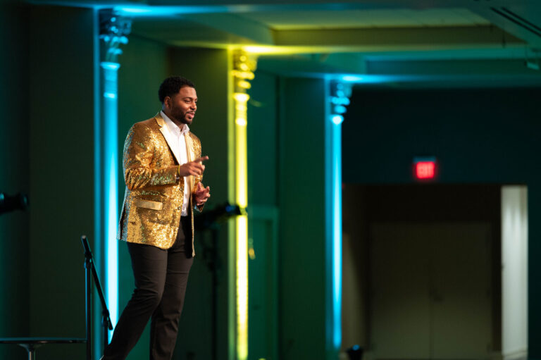 Presenter in a gold jacket on stage at the P&G Baby Care event, Music Hall Cincinnati