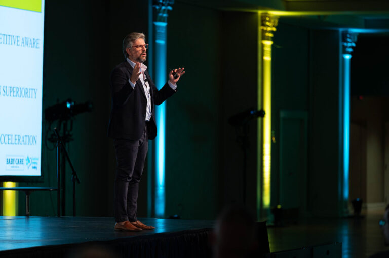 Speaker gesturing on stage at the P&G Baby Care event, Music Hall Cincinnati