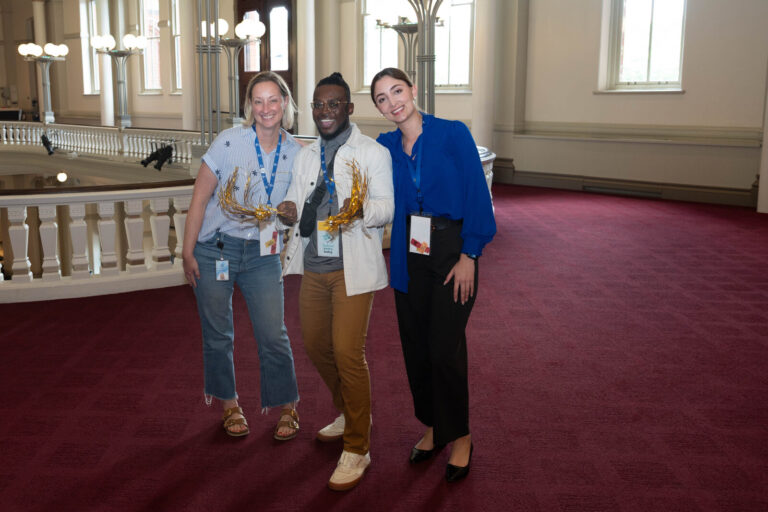 Three attendees posing in the hall at the P&G Baby Care event, Music Hall Cincinnati