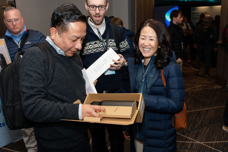Attendees opening Proofpoint welcome gifts at check-in