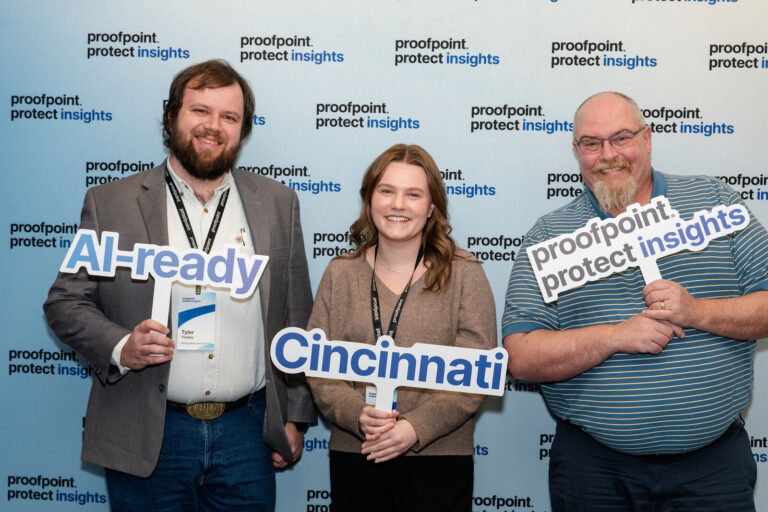 Attendees posing with AI-ready and Cincinnati signs at the photo backdrop