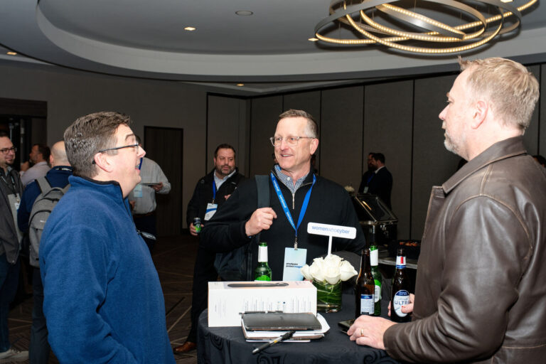 Attendees networking at a cocktail table at Proofpoint Protect Insights