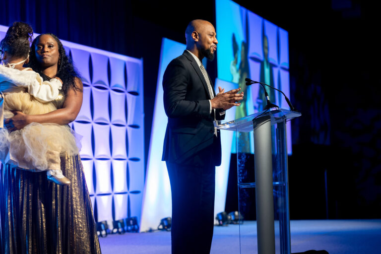 Family and speaker on stage at the Ronald McDonald House Charities gala, Northern Kentucky Convention Center